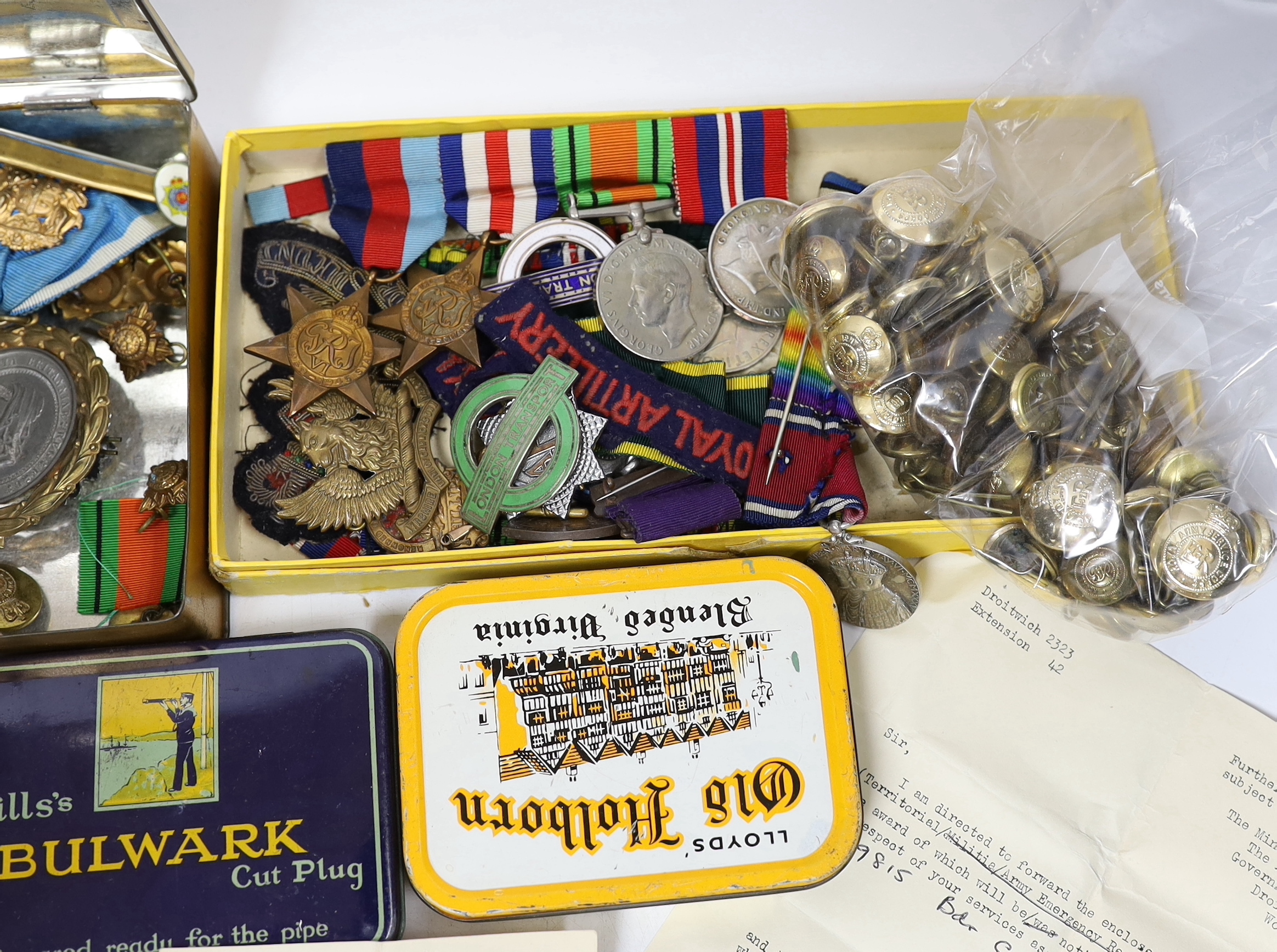 A collection of mostly unnamed WWI and WWII medals, cap badges and buttons, one pair named 24835 PTE. A. PRICE. R. W. KENT. R.